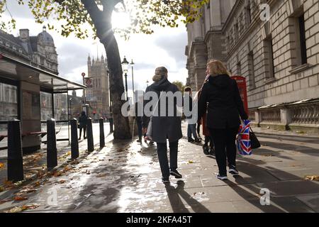 Die Menschen laufen entlang Whitehall, im Zentrum von London. Autofahrer werden gewarnt, sich nicht auf der Straße zu halten, da die Autos durch Regenfälle im Hochwasser stecken bleiben und das Vereinigte Königreich sich darauf vorbereitet, in den nächsten zwei Tagen unter „untragbaren Bedingungen“ zu leiden. Bilddatum: Donnerstag, 17. November 2022. Stockfoto