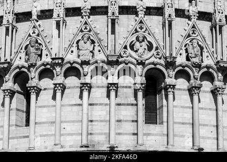 Schwarzweißfoto mit detaillierten Statuen von Heiligen, die die Fassade der katholischen Basilika in Pisa schmücken Stockfoto