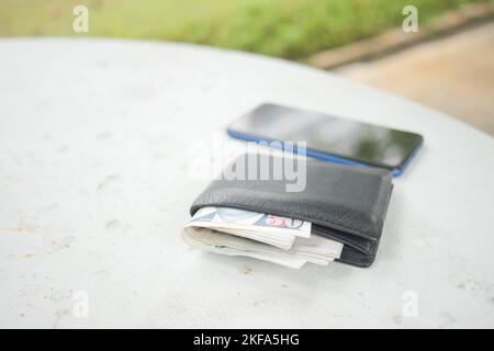 Hinterließ Geldbörse auf einer Bank im Park Stockfoto