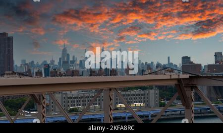 Panorama des dramatischen Himmels über den Wolkenkratzern von Lower Manhattan bei Sonnenuntergang, von der Brooklyn Bridge aus gesehen Stockfoto