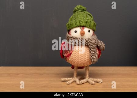 Gestrickter Rotkehlchen auf einem Holztisch. Ideal zum Hinzufügen von Text zu einer Folie für Schablonen Stockfoto