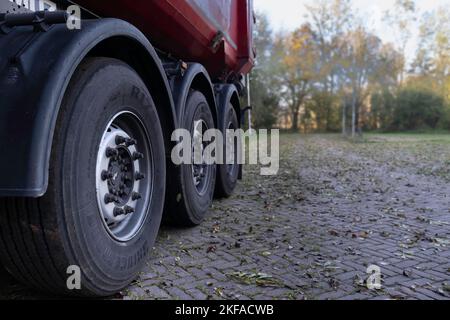 Sattelauflieger eines LKW mit großen Reifen, von der Seite nach hinten auf einer Straße betrachtet. Güterverkehr. Der richtige Platz für Text oder Design Stockfoto