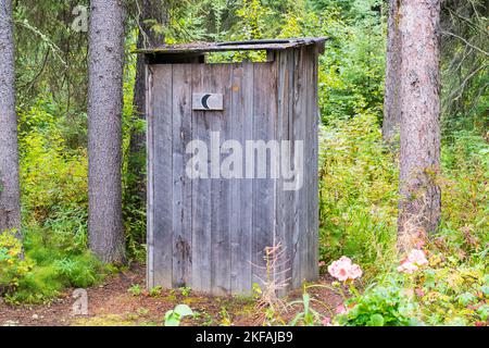 Rustikales und verwittertes altes Holzhaus im Wald Stockfoto