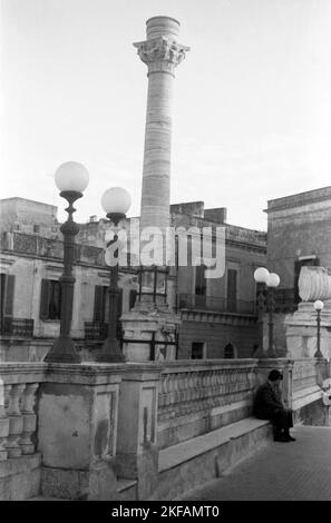 Ein Mann und eine Frau sitzen an einer Brüstung im Griechenland Korfu der 1950er Jahre. Ein Mann und eine Frau sitzen auf einer Brüstung in 1950s Griechenland Korfu. Stockfoto