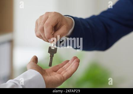 Mann nimmt Schlüssel von Immobilienmakler nach der Unterzeichnung Leasing-oder Kaufvertrag. Stockfoto