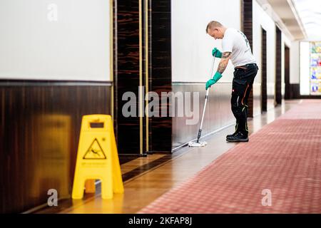 17. November 2022, Bremen: Lukas Bothe aus Mecklenburg-Vorpommern, Teilnehmer des nationalen Wettbewerbs im Bereich Gebäudereinigung, reinigt den Boden in einem Flur im Haus des Reiches. Beim jährlichen Wettbewerb treten Gesellen aus mehreren deutschen Bundesländern in verschiedenen Disziplinen der Gebäudereinigung gegeneinander an. Foto: Hauke-Christian Dittrich/dpa Stockfoto