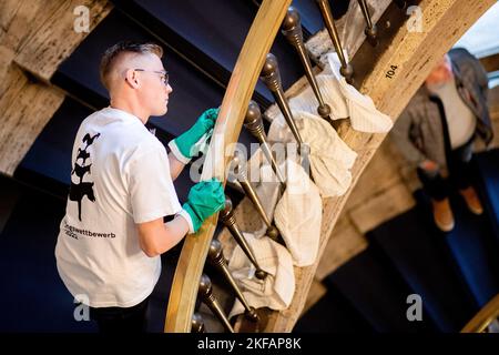 17. November 2022, Bremen: Philipp Neumann aus Thüringen, Teilnehmer des nationalen Wettbewerbs im Bereich Gebäudereinigung, reinigt im Haus des Reiches ein Treppengeländer aus Messing. Beim jährlichen Wettbewerb treten Gesellen aus mehreren deutschen Bundesländern in verschiedenen Disziplinen der Gebäudereinigung gegeneinander an. Foto: Hauke-Christian Dittrich/dpa Stockfoto