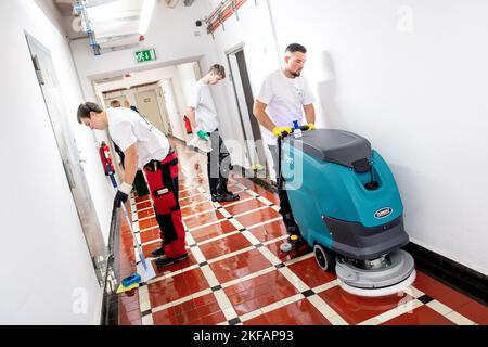 17. November 2022, Bremen: Drei Teilnehmer des nationalen Wettbewerbs in der Gebäudereinigung reinigen einen Fliesenboden im Haus des Reiches. Beim jährlichen Wettbewerb treten Gesellen aus mehreren deutschen Bundesländern in verschiedenen Disziplinen der Gebäudereinigung gegeneinander an. Foto: Hauke-Christian Dittrich/dpa Stockfoto