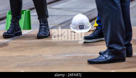 Wismar, Deutschland. 17.. November 2022. Auf dem Boden der Bühne liegt während der Pressekonferenz zum weiteren Bau des zukünftigen Disney-Kreuzfahrtschiffes ein Bauhelm mit dem Logo der ehemaligen MV-.Werften. Nach der Insolvenz von MV Werften im Januar 2022 wurde ein Käufer für das unvollendete Kreuzschiff „Global Dream“ gefunden. Disney Cruise Line beabsichtigt, das Schiff unter der Leitung von Experten der Meyer Werft am Standort MV Werften in Wismar fertigstellen zu lassen. Quelle: Jens Büttner/dpa/Alamy Live News Stockfoto