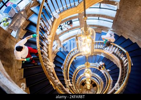 Bremen, Deutschland. 17.. November 2022. Mehrere Teilnehmer des nationalen Wettbewerbs in der Gebäudereinigung reinigen im Haus des Reiches ein Treppengeländer aus Messing. Beim jährlichen Wettbewerb treten Gesellen aus mehreren deutschen Bundesländern in verschiedenen Disziplinen der Gebäudereinigung gegeneinander an. Quelle: Hauke-Christian Dittrich/dpa/Alamy Live News Stockfoto