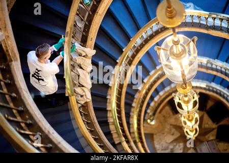 Bremen, Deutschland. 17.. November 2022. Philipp Neumann aus Thüringen, Teilnehmer des nationalen Wettbewerbs in der Gebäudereinigung, reinigt im Haus des Reiches ein Treppengeländer aus Messing. Beim jährlichen Wettbewerb treten Gesellen aus mehreren deutschen Bundesländern in verschiedenen Disziplinen der Gebäudereinigung gegeneinander an. Quelle: Hauke-Christian Dittrich/dpa/Alamy Live News Stockfoto