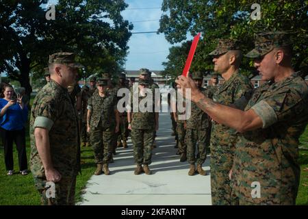 US Navy Cmdr. James M. Peugh, links, der Kommandoplan mit Marine Corps Installationen East (MCIEAST)-Marine Corps Base (MCB) Camp Lejeune und U.S. Marine Corps Brig. General Andrew M. Niebel, der mittlere, kommandierende General, MCIEAST-MCB Camp Lejeune, steht an der Position der Aufmerksamkeit, während Sgt. Maj. Robert Tellez, Sergeant Major, MCIEAST-MCB Camp Lejeune liest den Promotionsbefehl für MCB Camp Lejeune, North Carolina, 1. September 2022. Der Kaplan entwickelt das Personal und die Familien der Gemeinde Camp Lejeune für die geistliche und persönliche Bereitschaft durch Ministerien oder Seelsorge. Stockfoto