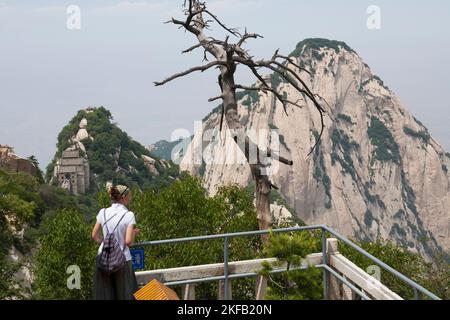 Westliche Touristin, weiß, und sehen Sie die Landschaft von der Aussichtsplattform entlang des Wanderpfads über die Gipfel des Huashan Berges / Mount Hua / Mt Hua bei Huayin, Weinan, China. 714299. (125) Stockfoto