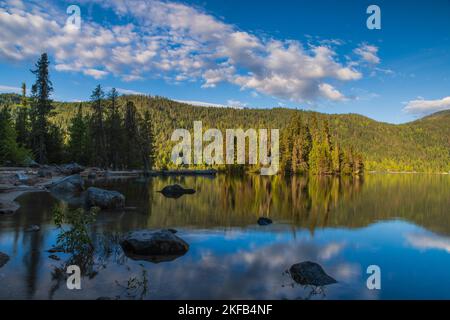 Am frühen Morgen taucht das Licht den Wenatchee-See an einem ruhigen, ruhigen Frühlingstag in die Sonne und macht ihn zu einem attraktiven Urlaubsziel Stockfoto