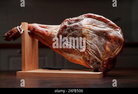 Trockengehärteter spanischer Schinken. Jamon auf einem Holzständer. Stockfoto