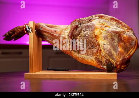 Trockengehärteter spanischer Schinken. Jamon auf einem Holzständer. Stockfoto