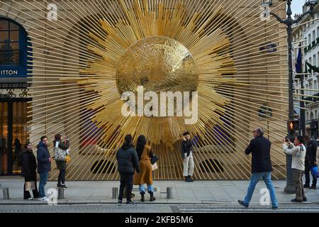 Paris, Ile de France, FRANKREICH. 17.. November 2022. Touristen fotografieren vor einer riesigen künstlichen Sonne auf dem Louis Vuitton, eine mögliche Referenz auf den Sonnenkönig oder ROI Soleil, Louis XIV, Shop auf dem Place Vendome in Paris. (Bild: © Remon Haazen/ZUMA Press Wire) Stockfoto