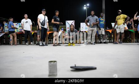 Flieger des Air Expeditionary Wings 380. lernen das Spiel „Tumbang Preso“ während der International Heritage Night, 2. September 2022, auf dem Luftwaffenstützpunkt Al Dhafra, Vereinigte Arabische Emirate, zu spielen. Tumbang Preso oder „Knock Down the Prisoner“ ist ein traditionelles philippinisches Kinderspiel, bei dem ein Schuh auf eine Flasche oder Dose geworfen wird, während ein anderer Spieler das Ziel bewacht. Stockfoto