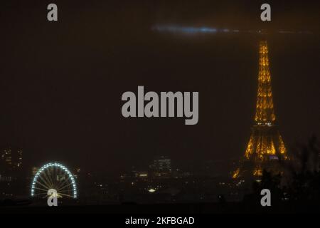 Das Foto zeigt den Eiffelturm und das im Nebel beleuchtete Riesenrad in Paris, Frankreich, am 16. November 2022. Foto von Aurelien Morissard/ABACAPRESS.COM Stockfoto