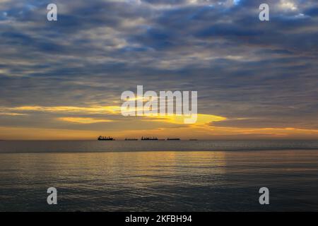 Sonnenaufgang über der Ostsee mit Blick auf Schiffe, die auf der Horizont-Linie in Gdynia, Polen, segeln Stockfoto