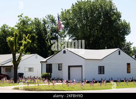 Extremer Patriotismus - kleines weißes Haus mit hundert amerikanischen Flaggen im Hof Stockfoto