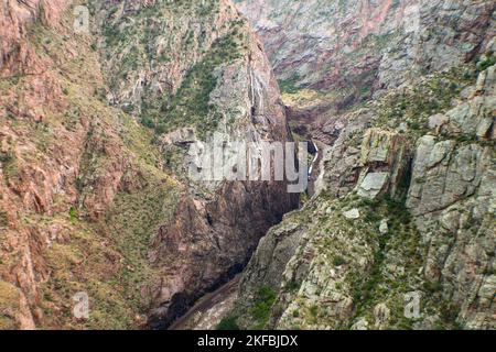 Blick weit hinunter auf den Arkansas River und der Zug, der daneben in der Royal Gorge in Colorado fährt Stockfoto