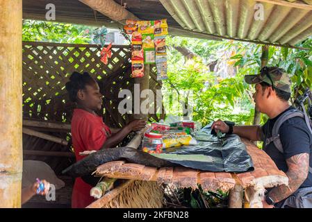 US Army Sgt. First Class Dan Calderon, Teammediziner, kauft am 13. September 2022 auf einem kleinen Markt im Dorf Woginara 2, Provinz East Sepik, Papua-Neuguinea Snacks für lokale Kinder ein. Das Untersuchungsteam besuchte mehrere Gebiete in der bergigen Provinz East Sepik in der Hoffnung, die während des Zweiten Weltkriegs verlorenen US-Dienstmitglieder wiederzufinden Die Mission der DPAA ist es, eine möglichst umfassende Abrechnung für vermisste und nicht bilanzierte US-Mitarbeiter für ihre Familien und die Nation zu erreichen. Stockfoto