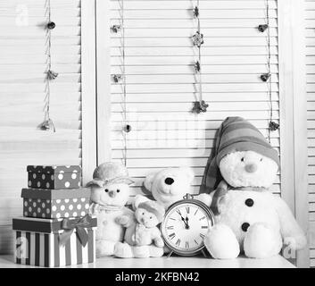 Schneemänner, Teddybären und Schachteln in der Nähe des Weckers Stockfoto