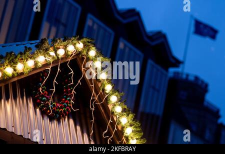 Bremen, Deutschland. 17.. November 2022. An einem Stand des Weihnachtsmarktes auf dem Marktplatz leuchten bei regnerischem Wetter zahlreiche Lampen, während im Hintergrund der Bremer Bundestag zu sehen ist. Der Weihnachtsmarkt auf dem Bremer Marktplatz beginnt am 21. November 2022. Quelle: Hauke-Christian Dittrich/dpa/Alamy Live News Stockfoto