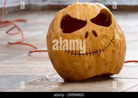 Junge Frau mit Kürbiskopf, nachdem sie ihn abgeschnitten und ein Gesicht darauf gesetzt hat, Halloween, Stockfoto