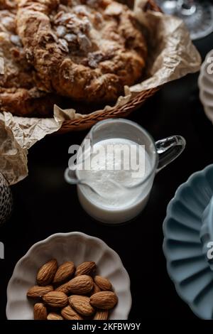 Ästhetisches Frühstück. Milchkaffee, Milchtee, Zucker, Mandel-, Mandelkuchen, Kekse, Marzipane und Puffs. Englisches Frühstück in einem gemütlichen Zuhause. Herbststimmung. Stockfoto