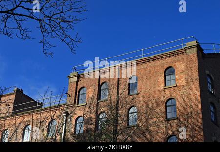 In der Nähe von Burscough befindet sich eine ehemalige Getreidemühle, die in Wohnungen und Wohnungen umgewandelt wurde und deren Ostwand in Herbstsonne getaucht ist. Stockfoto