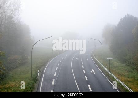 Leere Autobahn durch den Wald, im Nebel. Autobahn ohne Autos. Draufsicht. Stockfoto