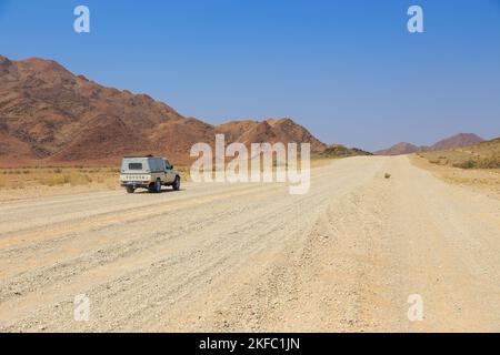 Sesriem, Naukluft , Namibia - 01. Oktober 2018: Typischer 4x4 Mietwagen in Namibia mit Campingausrüstung und einem Dachzelt, das auf einer unbefestigten Straße unterwegs ist Stockfoto