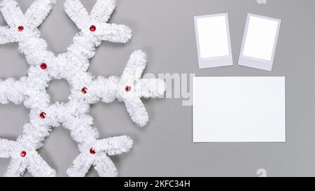 Polaroid retro Fotorahmen isoliert auf grauem Hintergrund. Vorlage für echte Fotos. Drei Bilder. Modell. Weihnachtliche weiße, flauschige Schneeflocke. Winterdekoration Stockfoto