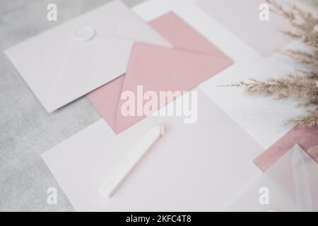 Draufsicht der Zusammensetzung von Papierblättern verschiedener Größen, weiße und rosa Umschläge mit Wachs versiegelt, Siegelwachs. Stockfoto