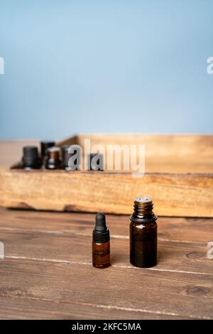 Ätherische Öle in kleinen Glasflaschen auf grauem Hintergrund. Selektiver Fokus- und Kopierbereich für Text. Naturkosmetikprodukte. Stockfoto