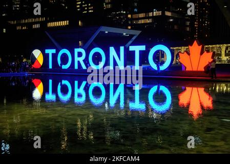 Toronto, Kanada - 11. August 2022: Toronto-Schild leuchtet nachts im Rathaus auf dem Nathan Phillips Square Stockfoto