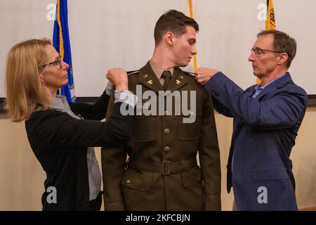 Jennifer Melia und Tom Melia stiften während einer Indienststellung im Auditorium des Regional Training Institute in Camp Net, Niantic, Connecticut, am 6. September 2022, ein Unterleutnant-Abzeichen auf die Uniform der US-Armee 2. LT. Jacob Melia. Melia aus Manchester, Connecticut, wird Quartermaster-Offizier bei Hotel Company, Brigade Support Bataillon 186.. Stockfoto