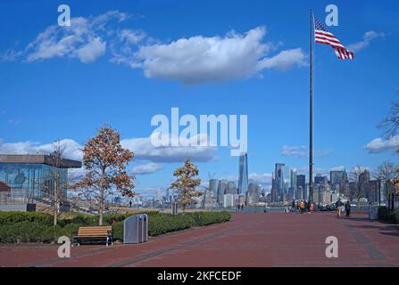 Liberty Island National Park, mit einem Museumsgebäude auf der linken Seite und der Skyline von Manhattan in der Ferne Stockfoto