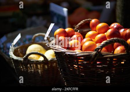 Zwei Körbe voller frischer Orangen und Pomelos werden auf einem Markt ausgestellt Stockfoto