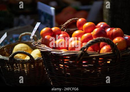 Zwei Körbe voller frischer Orangen und Pomelos werden auf einem Markt ausgestellt Stockfoto