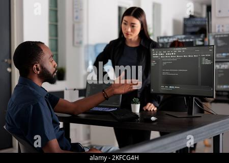 Vielfältiges Team von Softwareentwicklern, die HTML-Code und Cloud-Computing in der IT-Entwicklungsagentur entwickeln. afroamerikanischer Systemingenieur, der auf der Tastatur tippt, um ein Skript für künstliche Intelligenz zu erstellen. Stockfoto