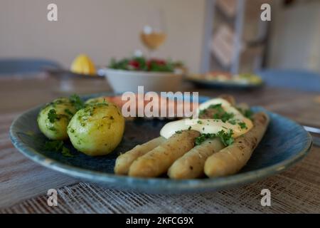 Eine Nahaufnahme aus gedämpften Kartoffeln, flämischem Spargel und gebackenem Lachs auf einem Teller Stockfoto