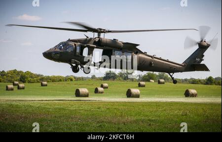 Ein Feld von Heuballen umrahmt einen Iowa Army National Guard UH-60 Black Hawk, der sich auf die Schlinge eines Anhängers während eines U.S. Pathfinder Course am 8. September 2022 in Camp Dodge in Johnston, Iowa, vorbereitet. Fast 30 Soldaten absolvierten den Kurs, der von einem mobilen Trainingsteam im Warrior Training Center der Army National Guard in Fort Benning, Georgia, unterrichtet wurde. Army Pathfinders werden geschult, um Navigationshilfe und Beratungsdienste für Militärflugzeuge in Gebieten zu leisten, die von unterstützten Einheiten-Kommandeuren bestimmt werden. Während des Pathfinder-Kurses werden die Studenten in der Flugzeugorientierung, Aero-Medical ev, unterwiesen Stockfoto