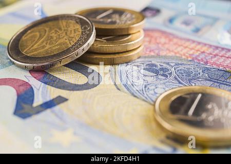Stapel von zwei und einer Euro-Münze auf einer Banknote von 20 Euro. Stockfoto