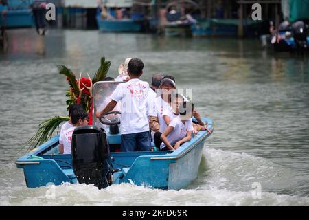 Eine Gruppe von Menschen, die mit einem Boot beim Drachenbootfest in Taio O, Hongkong, unterwegs sind Stockfoto