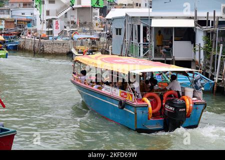 Eine Gruppe von Menschen, die mit einem Boot beim Drachenbootfest in Taio O, Hongkong, unterwegs sind Stockfoto