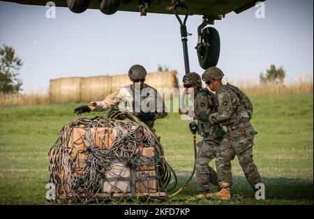 2. LT. Brilee Vargason, ein Mount Pleasant, Iowa, gebürtiger und Zugführer, der der Truppe A, der 1.. Staffel, dem 113.. Kavallerieregiment, der Iowa Army National Guard und Staff Sgt. Joshua Pauley, ein gebürtiger Infanterist aus Madrid, Iowa, der der Headquarters & Headquarters Company, 1. Bataillon, 168. Infantry Regiment, IANG, zugewiesen wurde, arbeitet zusammen, um während eines U.S. Pathfinder-Kurses am 8. September 2022 im Camp Dodge in Johnston, Iowa, Fracht an einen CH-47 Chinook-Hubschrauber zum Schlingentraden anzuhängen. Fast 30 Soldaten absolvierten den Kurs, der von einem mobilen Trainingsteam beim Krieg der Nationalgarde der Armee unterrichtet wurde Stockfoto