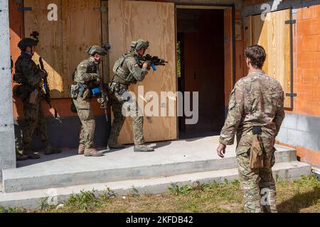 Ein Green Beret, der der 10. Special Forces Group (Airborne) zugewiesen wurde, arbeitet mit der Polnischen Brigade der 1. Territorialen Streitkräfte während eines simulierten Nahkampfes in Verbindung mit taktischen städtischen Bewegungsübungen in der Nähe von Bialystok, Polen, vom 6. Bis 10. September 2022 zusammen. Dies war die erste von vielen Trainingseinheiten zwischen polnischen 1. TDF und 10. SFG(A) und ermöglichte den Soldaten die Möglichkeit, ihre taktischen Fähigkeiten im Zusammenhang mit engen Viertelschlachten zu verbessern und die allgemeine Letalität zu erhöhen. Stockfoto